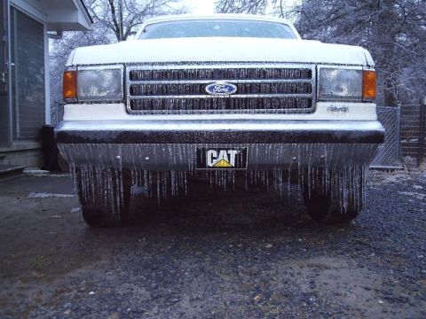 1989 Ford Bronco - A 1989 Ford Bronco is heavily coated in ice, with icicles hanging from its bumper and grille.