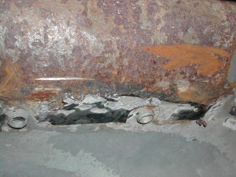 1994 Ford Bronco - Close-up of heavily rusted metal bracket showing signs of wear and repair.