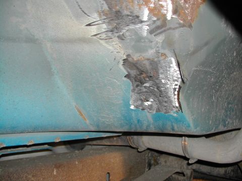 1994 Ford Bronco - Undercarriage view shows significant rust and damage to the fender area, with a section cut away.