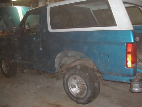 1994 Ford Bronco - This 1994 Ford Bronco is shown from the side, a teal body and a white removable top.