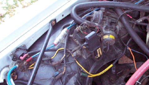 1985 Ford LTD Crown Victoria - Close-up view of the engine compartment wiring, including the fuse box and ignition coil.