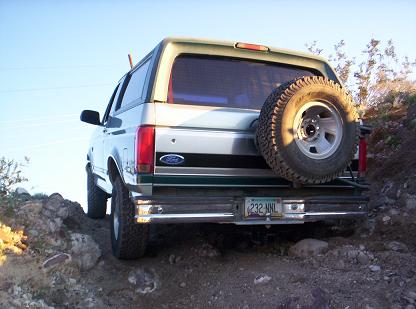 1996 Ford Bronco - This 1996 Ford Bronco is seen from the rear, with its spare tire mounted externally, navigating a rocky off-road path.