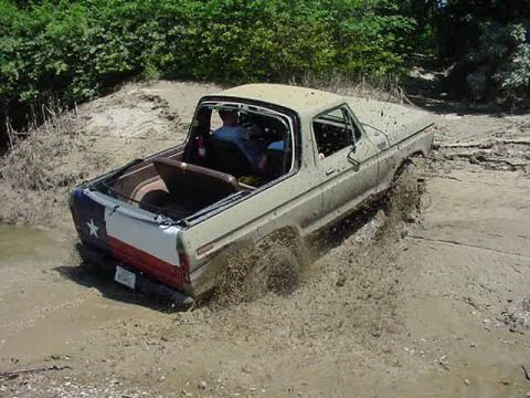 1978 Ford Bronco - This 1978 Ford Bronco is stuck deep in the mud, with a Texas flag decal visible on its rear.