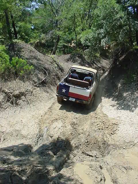 1978 Ford Bronco - This 1978 Ford Bronco, adorned with a Texas flag design, navigates a challenging off-road trail.