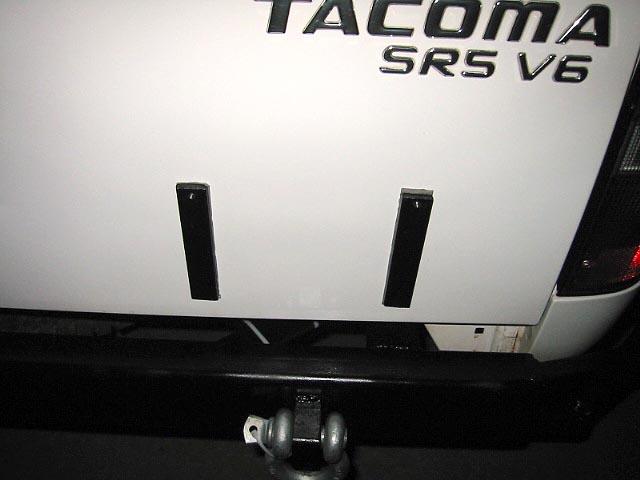 White Toyota Tacoma SR5 V6 rear tailgate with badging and black bumper