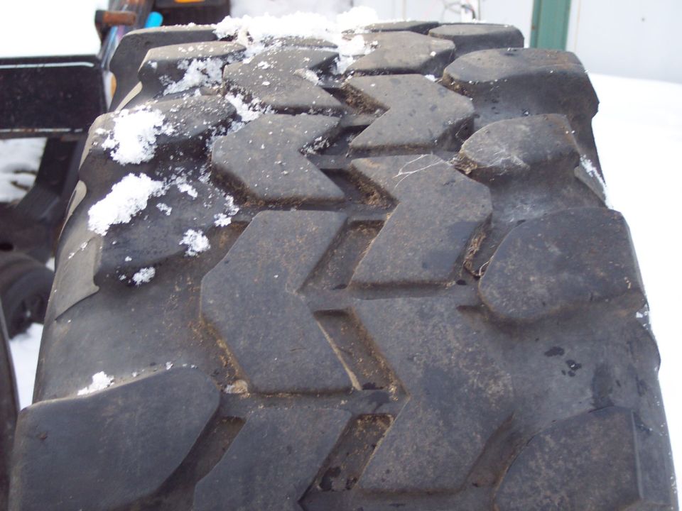 Close-up of a large tire tread with snow on it