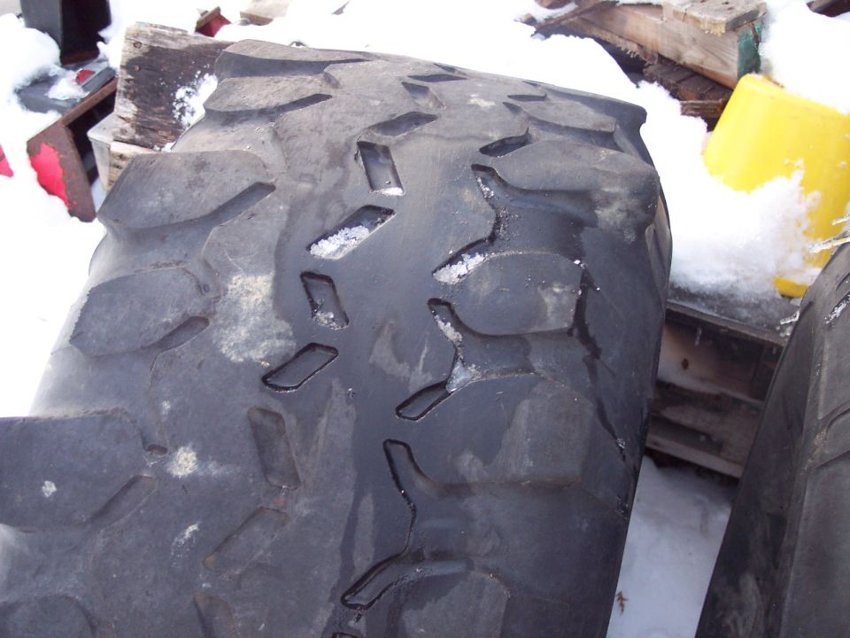 Close-up of a large, knobby tire with snow in its treads