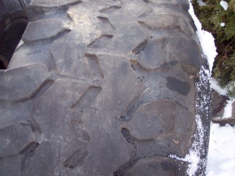 1974 Ford Bronco - Tire tread detail, Supermotors.net logo visible, with snow and foliage.