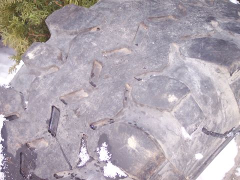 1974 Ford Bronco - A close-up view of a tire's tread pattern, with snow visible on the surface. The Supermotors.net logo is in the lower right corner.