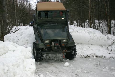 2003 Jeep TJ - A 2003 Jeep TJ navigates a snowy path, with another vehicle following in the distance.
