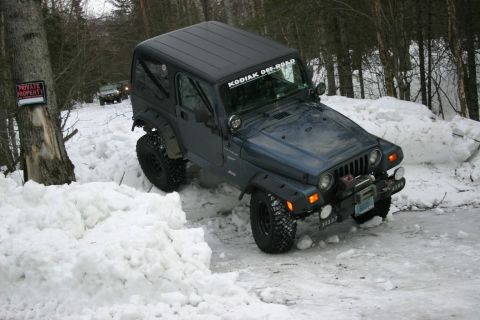 2003 Jeep TJ - A Jeep Wrangler TJ navigates a snowy trail with another vehicle following behind.