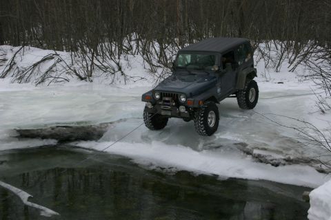 2003 Jeep TJ - A Jeep Wrangler TJ is winched across an icy river during winter.