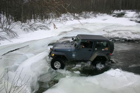2003 Jeep TJ - 2003 Jeep TJ navigates a frozen waterway during winter off-roading.