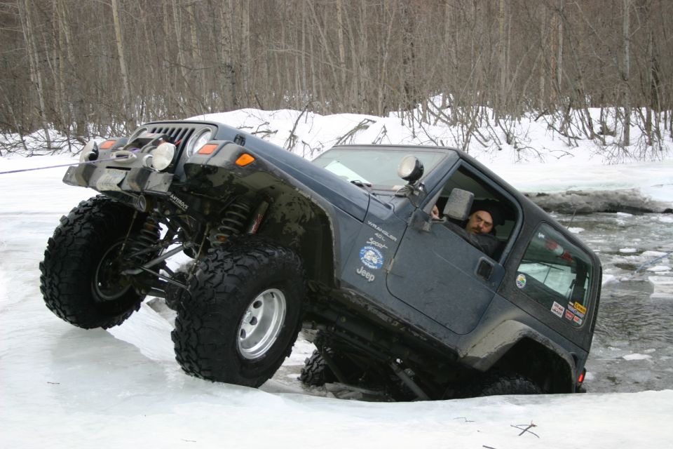 2003 Jeep TJ navigating icy terrain with driver visible