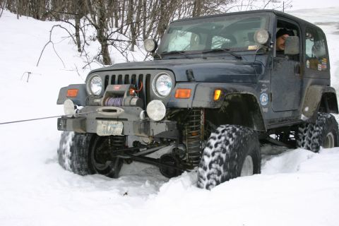 2003 Jeep TJ - A Jeep TJ is partially submerged in snow, with its winch ready for action.