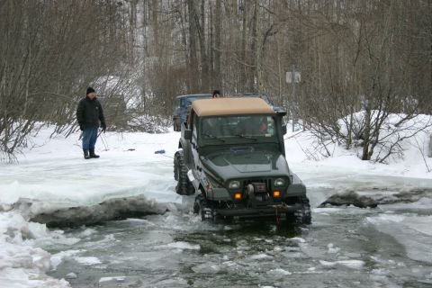 2003 Jeep TJ - A Jeep Wrangler navigates a partially frozen body of water during winter, with another vehicle following.