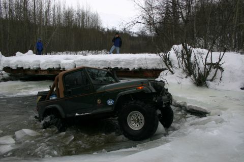2003 Jeep TJ - Green 2003 Jeep TJ navigates icy water during winter conditions.