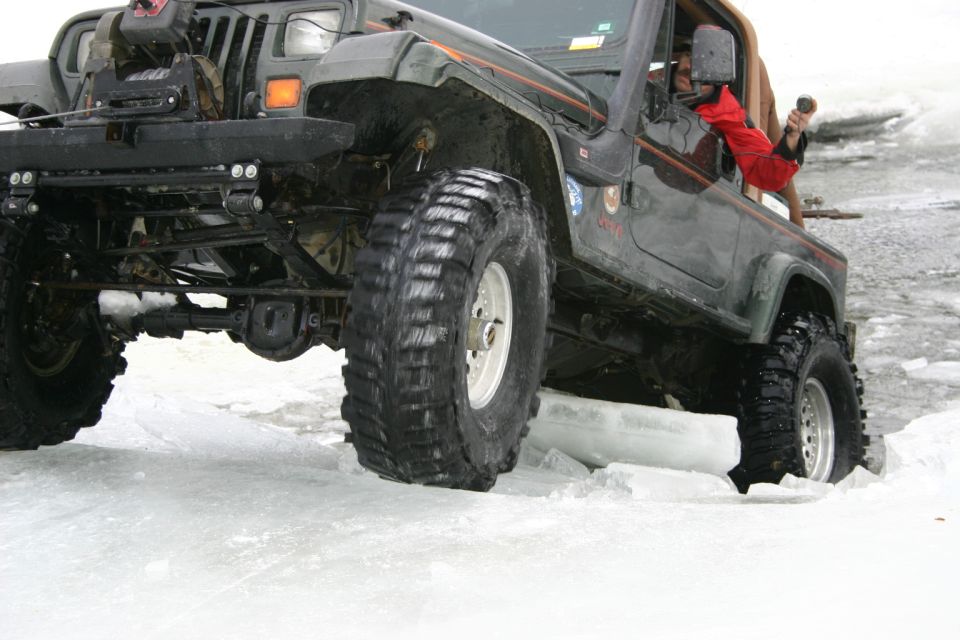 Dark green 2003 Jeep TJ on ice with large tires