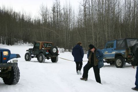2003 Jeep TJ - Multiple Jeeps are stuck in the snow with people attempting to tow one out.