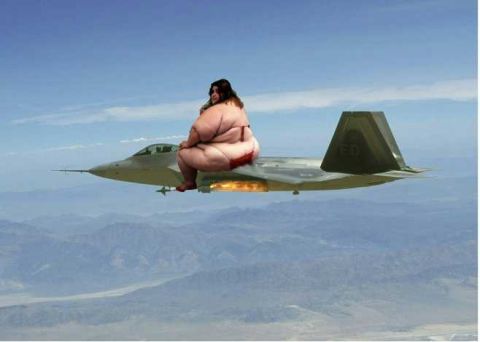 1993 Ford Bronco - A woman is seated on the fuselage of a fighter jet as it flies over mountains.