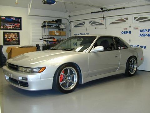 1992 Nissan 240SX - A silver coupe with a distinctive body style is parked in a garage.