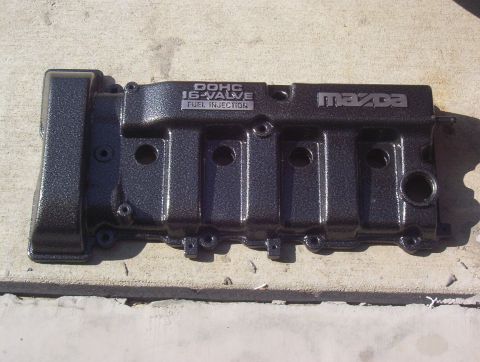 1997 Ford Probe - Mazda DOHC 16-valve fuel injection valve cover shown on a concrete surface.