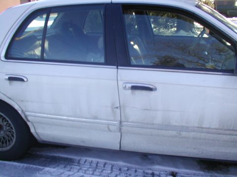 1979 Ford Bronco - A white sedan is shown from the side, with visible damage to the rear door.