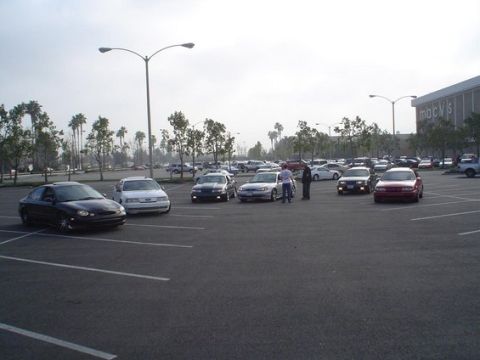 2002 Ford Taurus - Several cars are gathered in a parking lot, with a Macy's store visible in the distance.