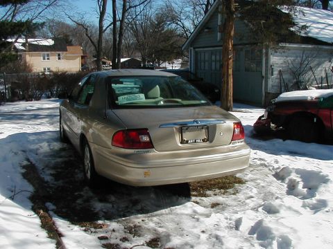 2001 Mercury Sable - Rear view of a 2001 Mercury Sable parked in a snowy driveway next to a garage.