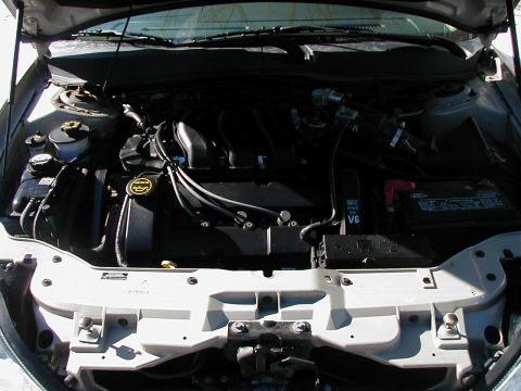 2001 Mercury Sable - The engine bay of a car is shown with the hood open, revealing the V6 engine and associated components.