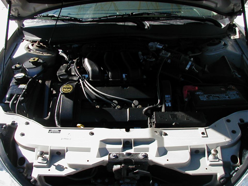 engine bay with V6 engine, battery, and fluid reservoirs visible