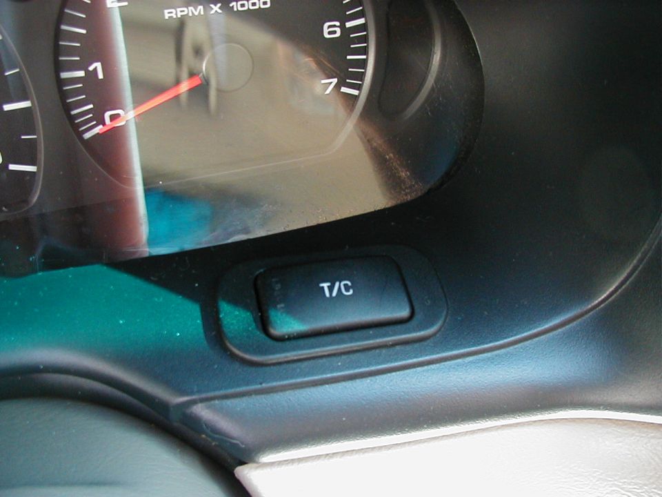 Car tachometer reading zero above a dashboard T/C traction-control button
