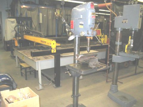 1991 Ford Bronco - An industrial workshop scene two drill presses and a yellow robotic arm. The registry incorrectly identifies this as a 1991 Ford Bronco.