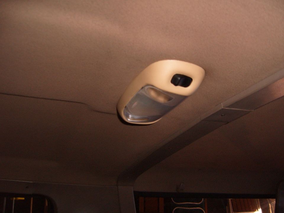 Tan dome light with clear lens and rocker switch in a truck's tan headliner