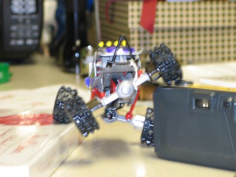 1992 Ford Bronco - Toy remote control car with large tires is positioned on a table next to a camera.