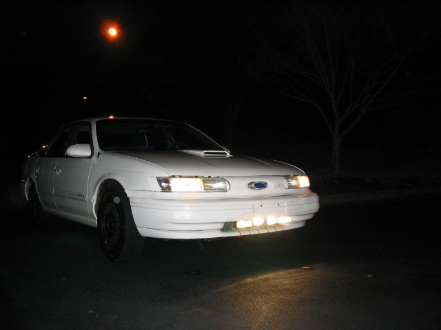 White 1995 Ford Taurus front 3/4 view at night
