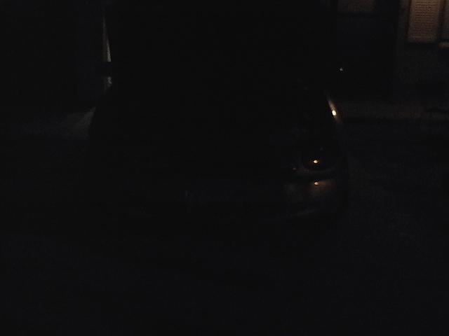 Very dark photo with faint reflections on a wet surface