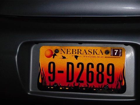 1999 Ford Taurus - A Nebraska license plate with a flame design is mounted on the rear of a vehicle.