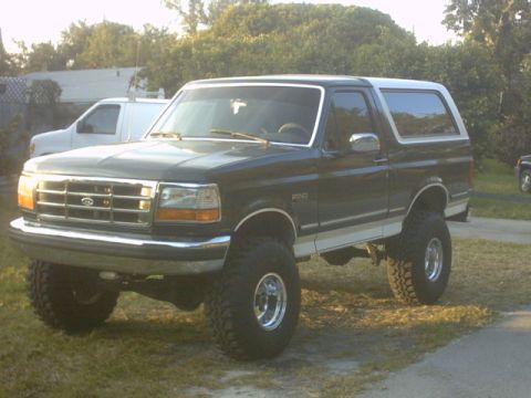 1992 Ford Bronco - This lifted 1992 Ford Bronco features a two-tone paint scheme with a dark green body and white top and trim.