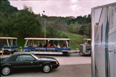 1985 Ford Mustang - A black 1985 Ford Mustang convertible is seen alongside a Universal Studios tram tour.