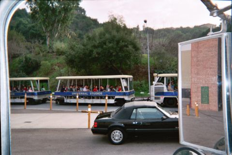 1985 Ford Mustang - A black 1985 Ford Mustang convertible is seen alongside Universal Studios trams.