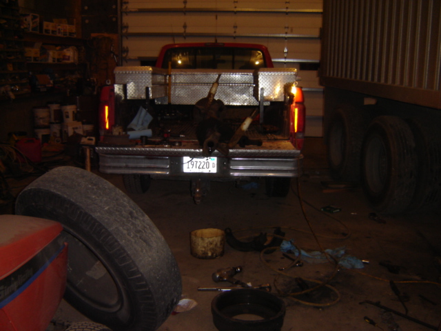 Red pickup truck rear view with toolbox and animal carcass in bed