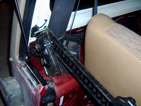1998 Jeep TJ - Hi-lift jack installed inside vehicle interior, adjacent to passenger seat.