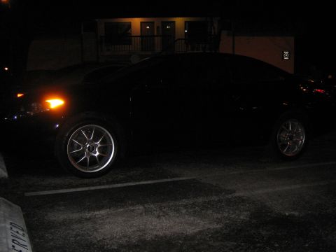 2004 Toyota Solara - A dark sedan is parked in a lot at night, with its hazard lights on.