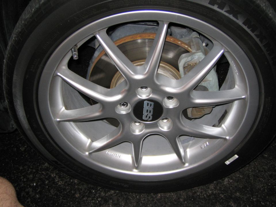 Silver BBS ten-spoke alloy wheel with black center cap on Michelin tire, brake rotor behind