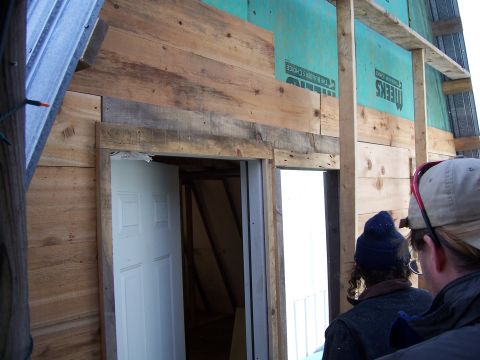 1999 Jeep TJ - Two individuals observe a construction project unfinished wooden walls and a doorway.