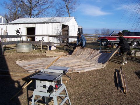 1999 Jeep TJ - People are working with a large tarp and a table saw in a rural setting with a pickup truck nearby.
