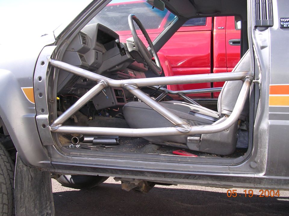 Gray Ford Bronco driver's side with fabricated tubular-steel tube door and stripped interior