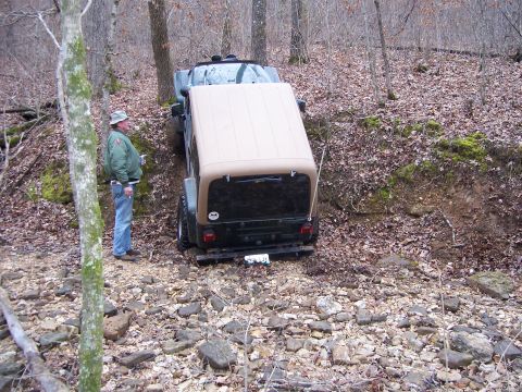 1999 Jeep TJ - Jeep Wrangler navigates a challenging off-road course with a companion observing.