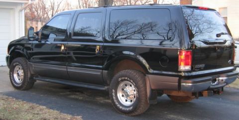 2001 Ford Excursion - Rear three-quarter view of a black 2001 Ford Excursion parked in a driveway.
